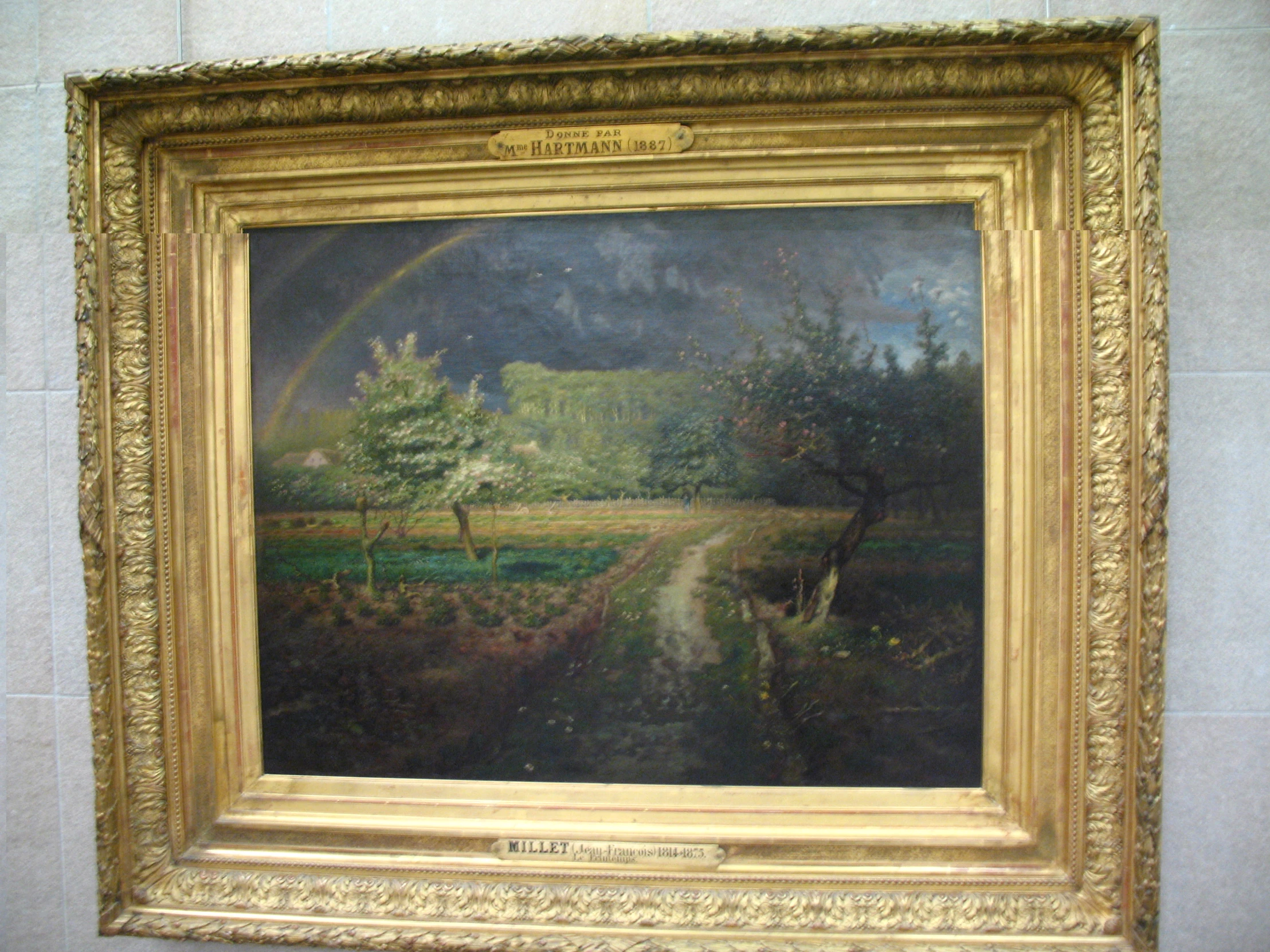 an empty frame that has a painting of a forest with a rainbow in it