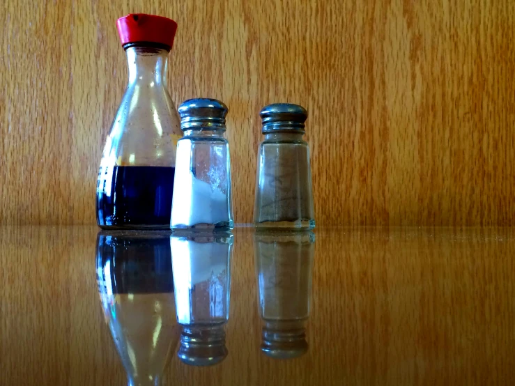 a couple of bottles with blue liquids on top of a wooden table