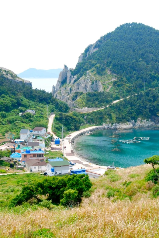 an area with buildings, beach and hills on the side