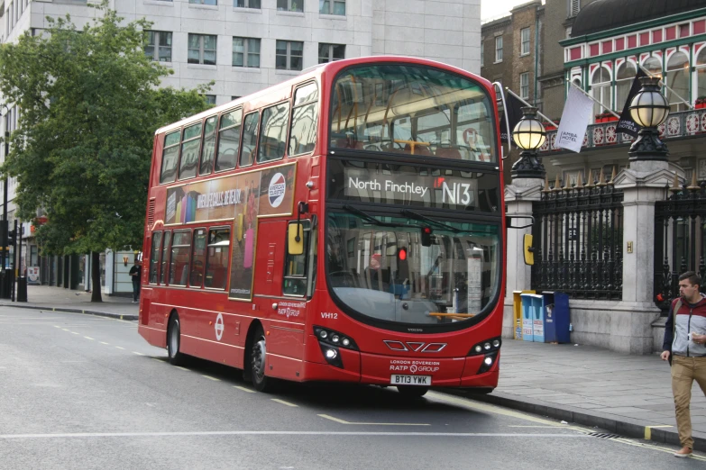 a large red double decker bus on a city street