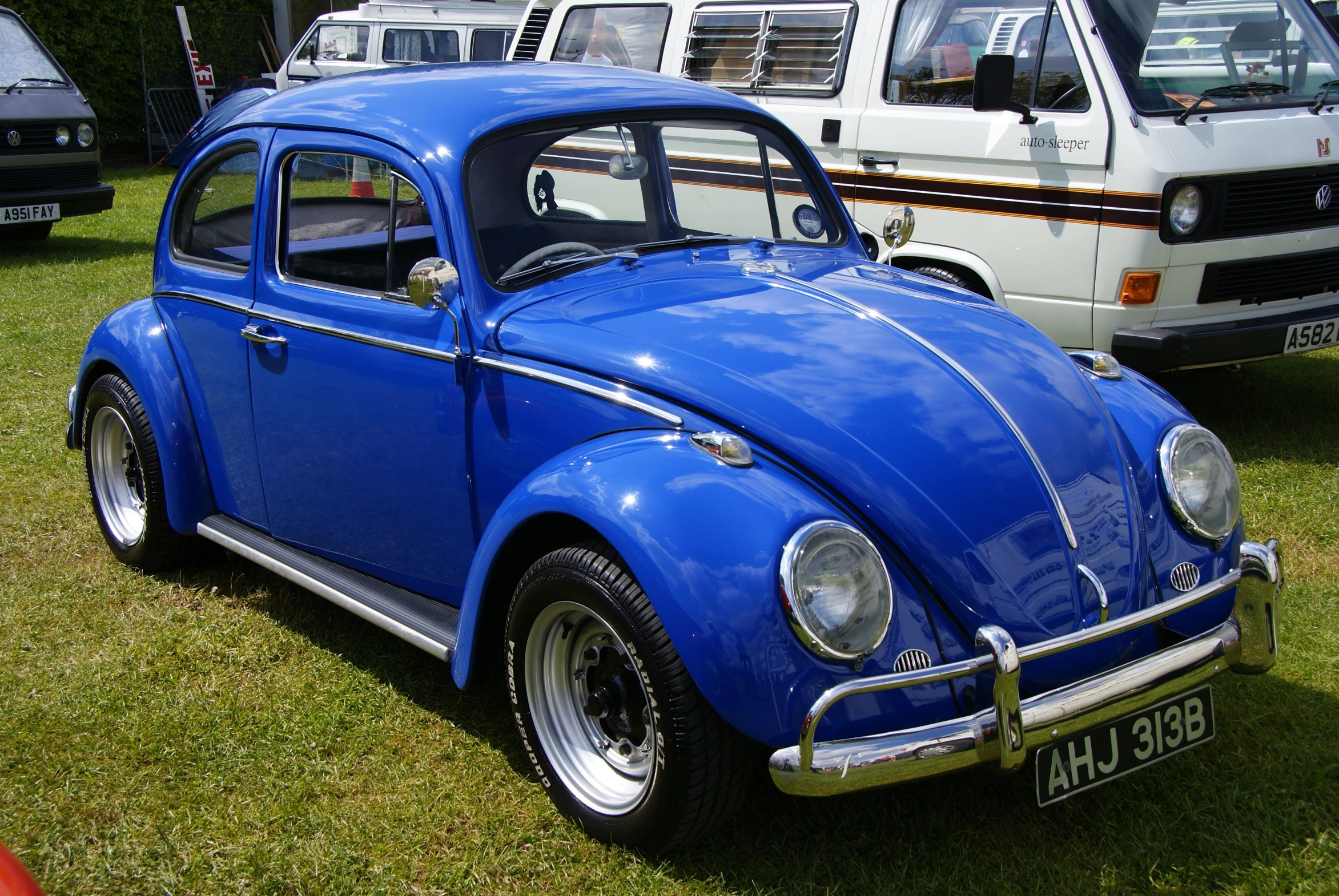 old, vintage vw bug cars in a field