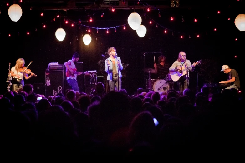 some people are on stage playing the guitar