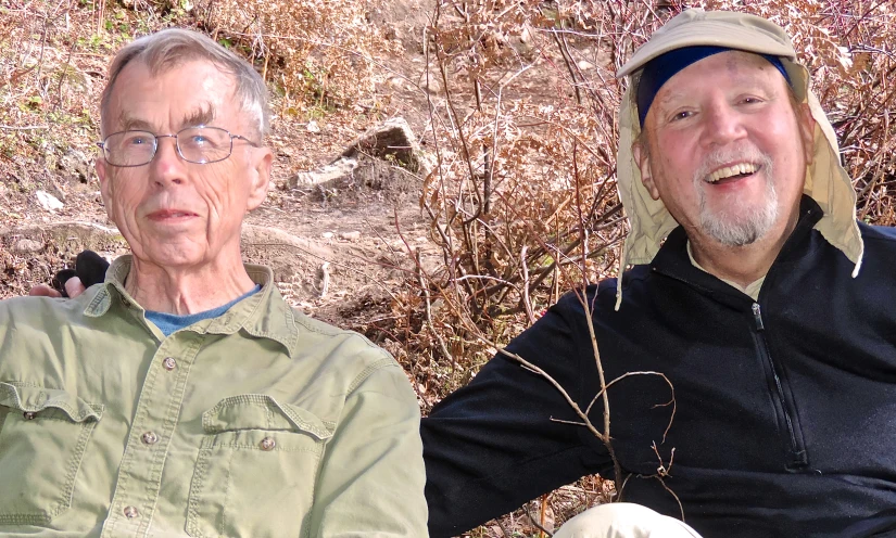 an older man wearing a hat with another older man