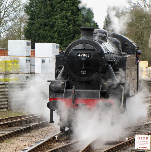 a black steam engine sitting on the tracks