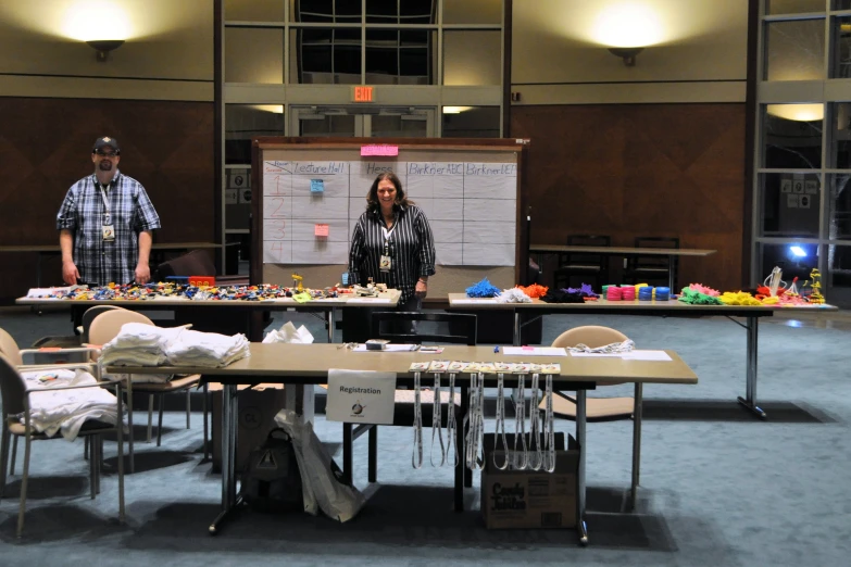 two people standing by a table with various items on it