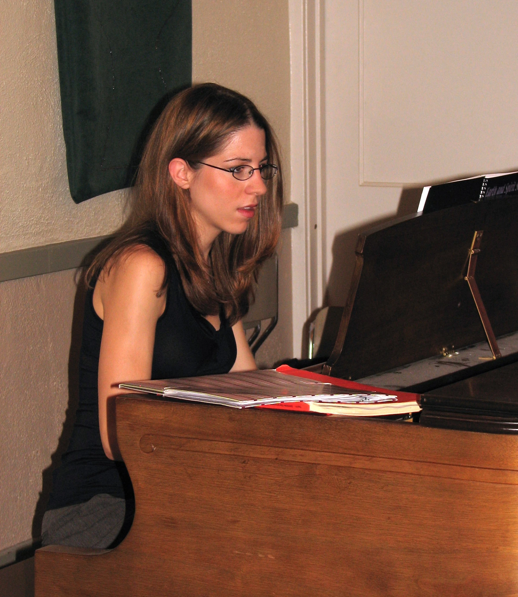 a girl sitting at a table with a book near her