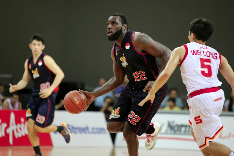 three basketball players running down the court with one holding the ball