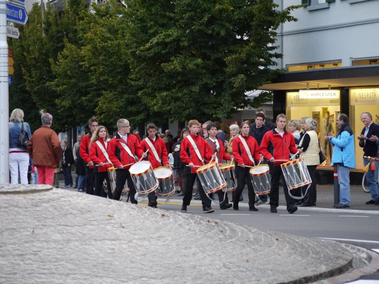 a group of musicians dressed in red marching gear