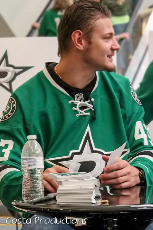 a man in a green uniform holding a hockey stick