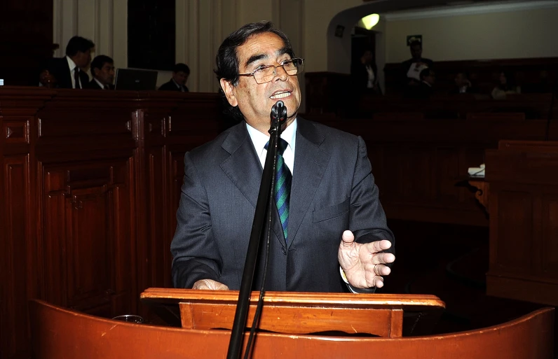 the man wearing a suit is giving a speech