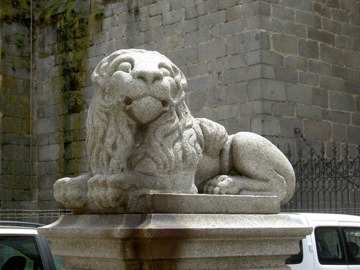 a lion statue next to a car on a road