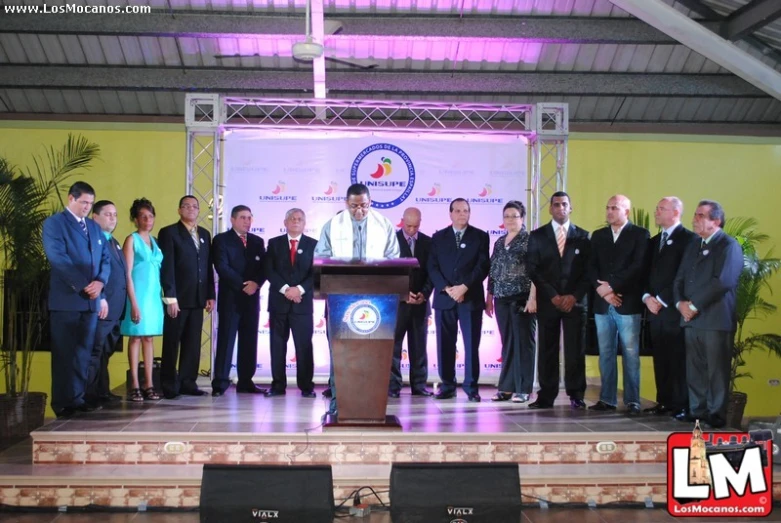 group of people in suits standing at podiums behind podium