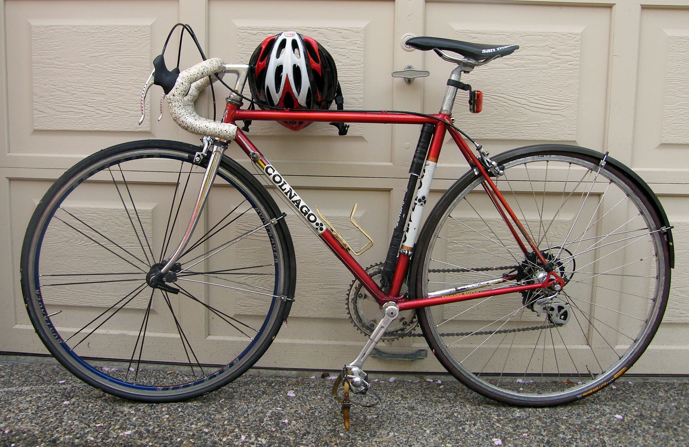 a bicycle in front of a garage door that is locked up