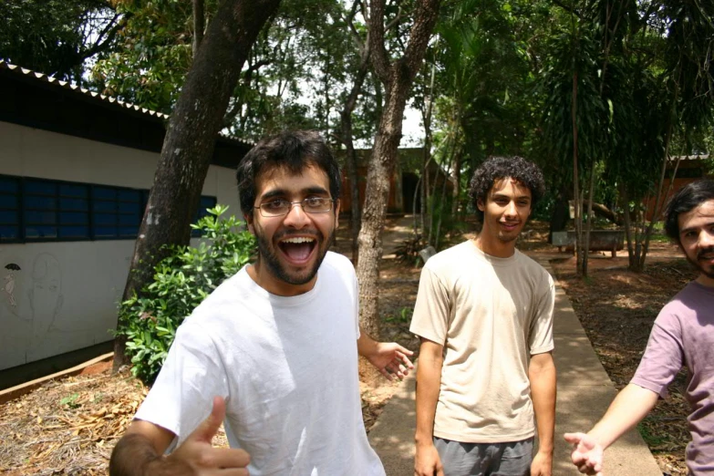 three men who are standing together and one has his tongue out