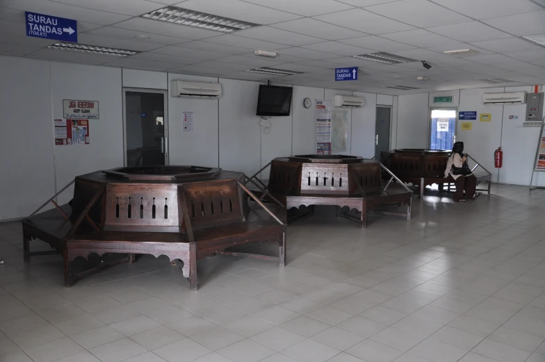 a man is sitting in front of a lot of chairs