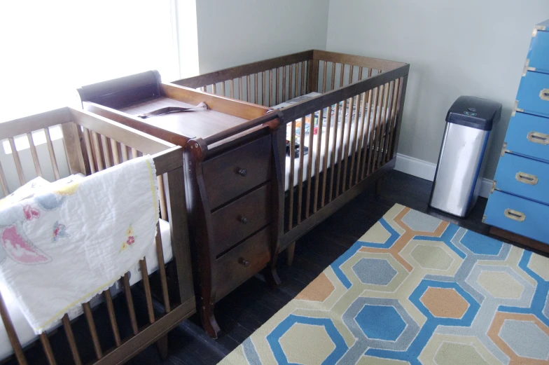 an infant's room is shown with a crib and dressers