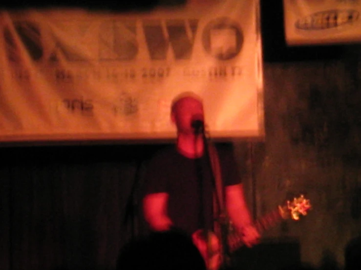 the man playing a guitar at the stage