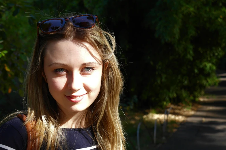 a  smiling wearing glasses in front of a wooded background