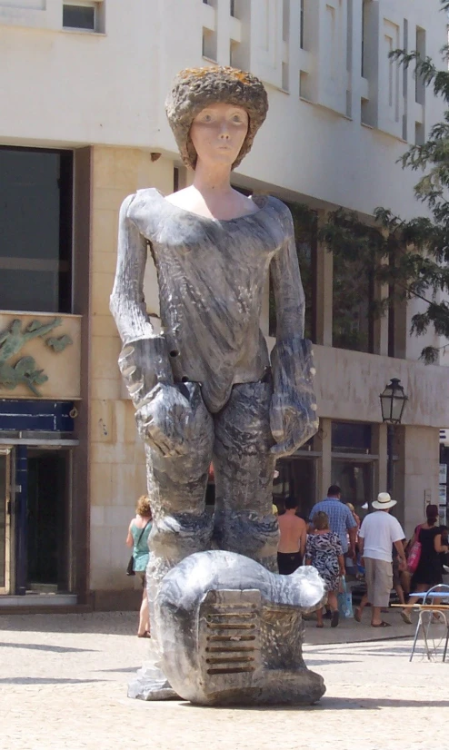 a large statue stands in the middle of a sidewalk