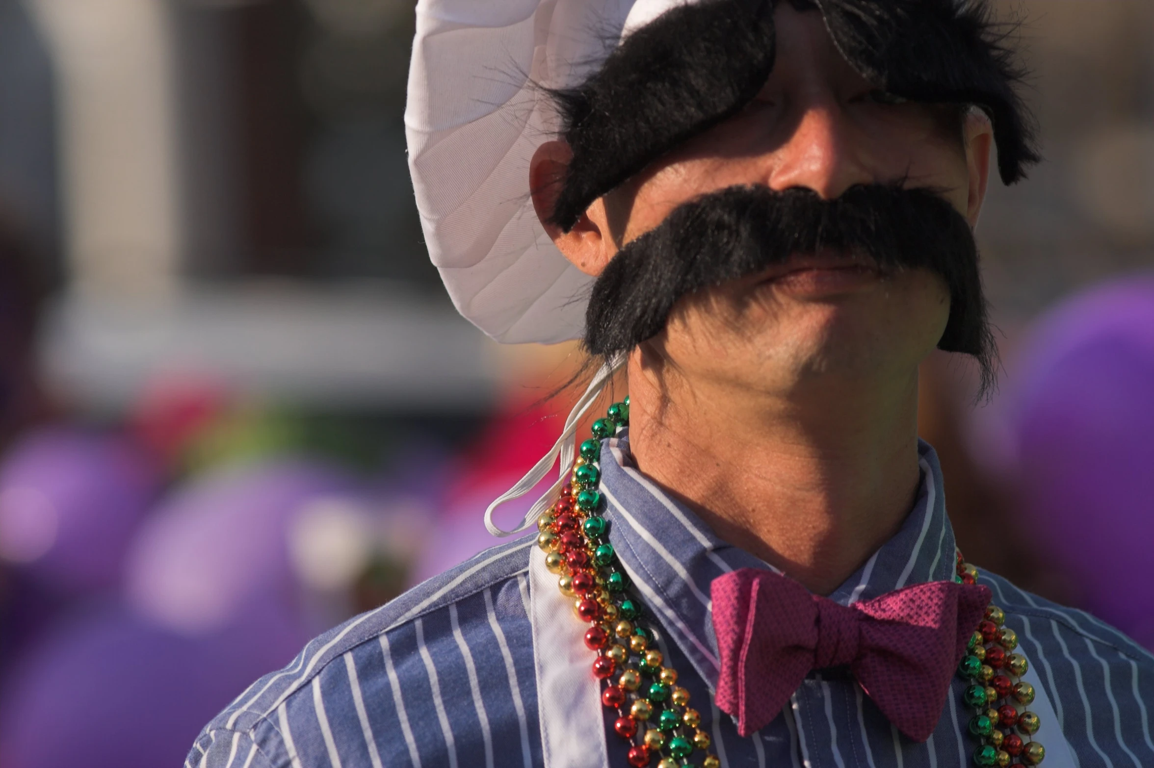 a man has his nose ring a a top hat and beads