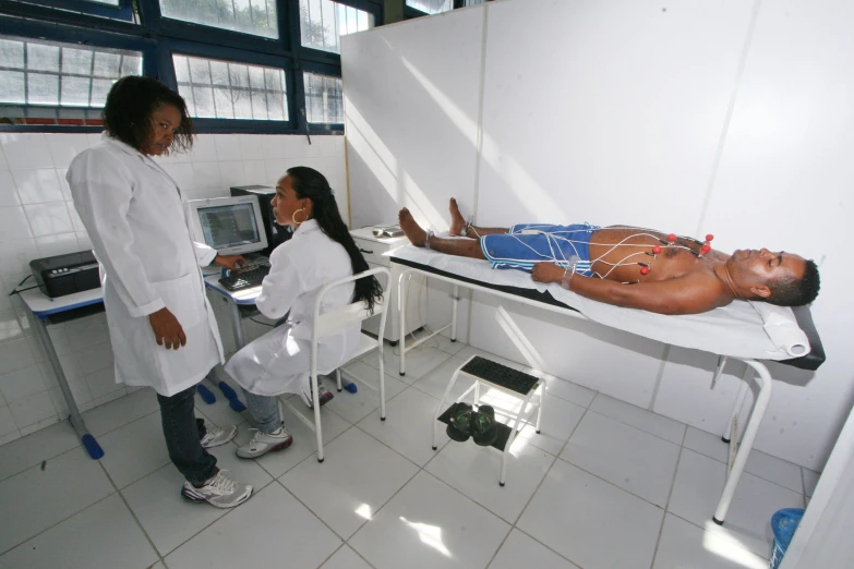 two young doctors examine a baby laying on a bed