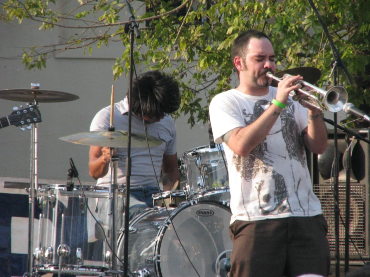 a man playing the trumpet while standing near other men