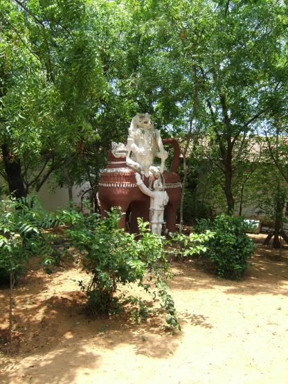 a garden statue surrounded by many green trees