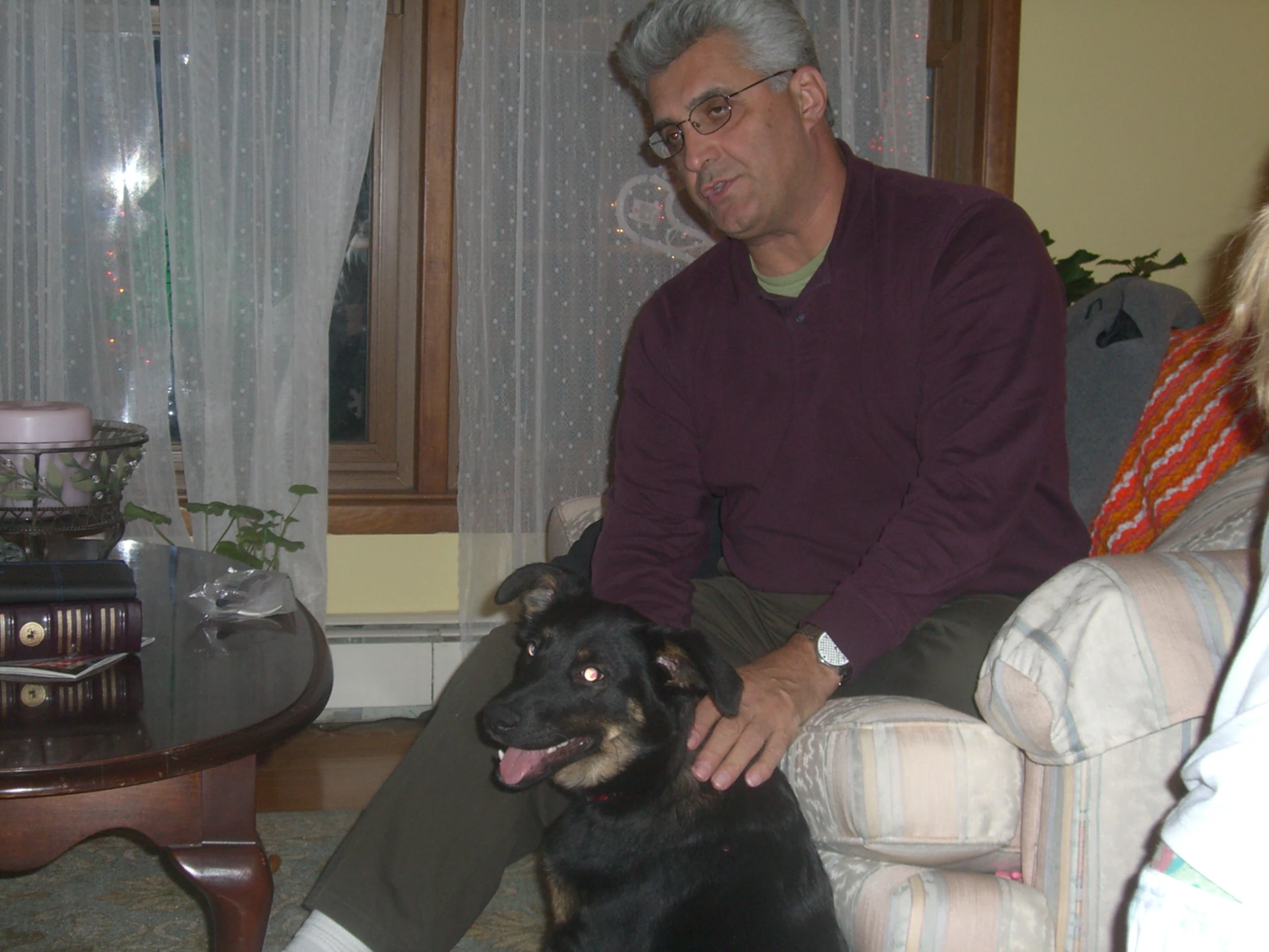 a man sitting next to a dog on top of a couch