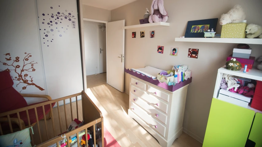 a baby room is painted in pink and green