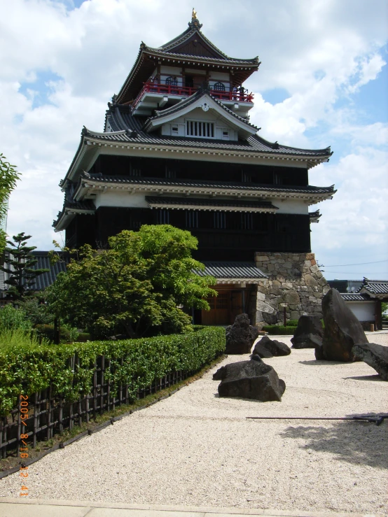 an asian style building has a rock garden in front