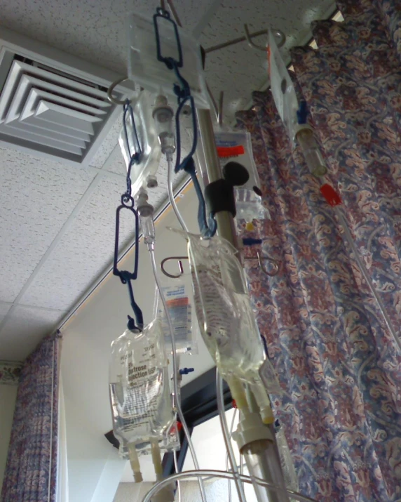 bottles hung from a medical ceiling line, some of them empty