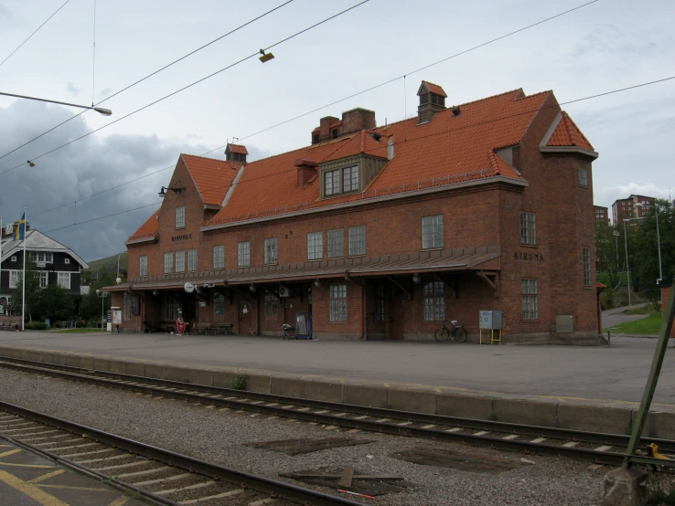 an old red brick building that's on a train track