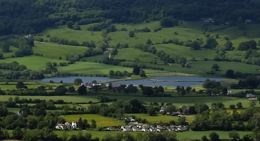 green hills, fields, and a blue lake