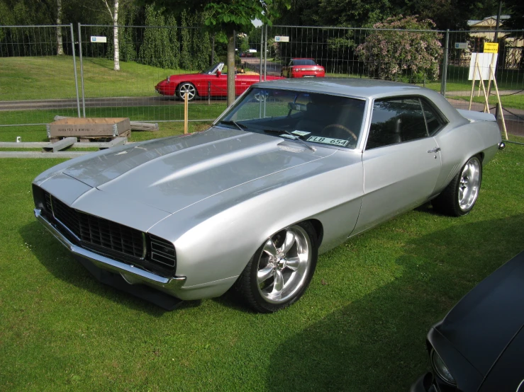 a vintage car sitting in a grassy yard