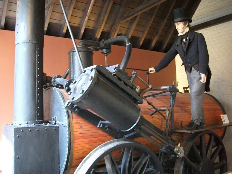 an old fashioned locomotive with a man standing on top