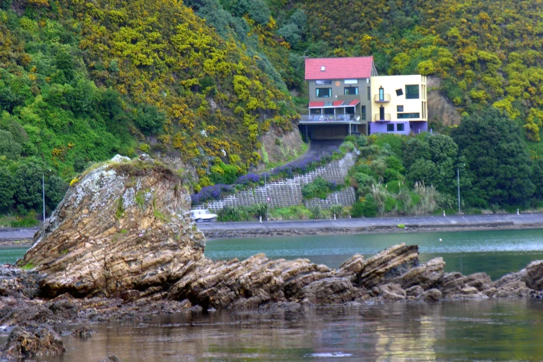 this home is on the top of a cliff by the water