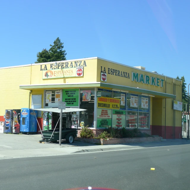 a yellow and green business sitting on the side of a road