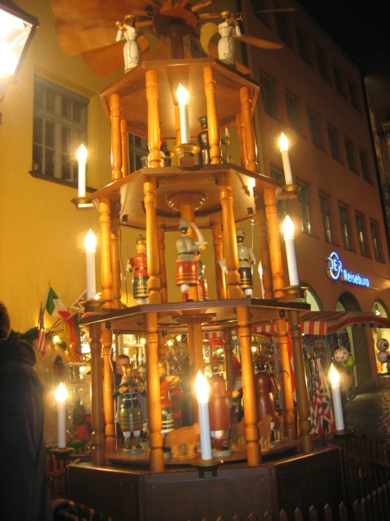 candles are arranged on top of a stand on the street