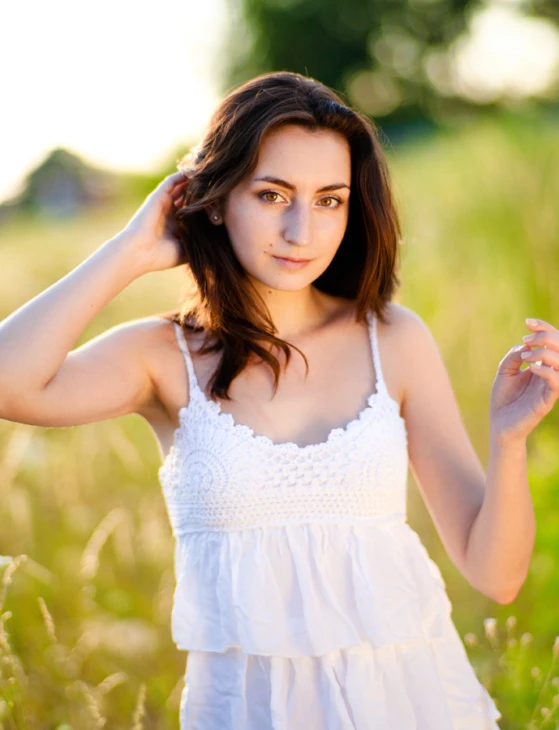 a woman in a white dress holds her head in her hair