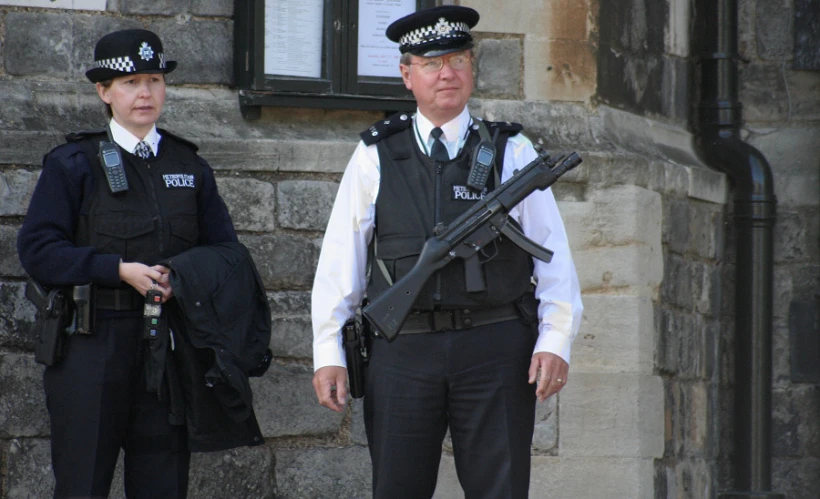 a man in a police uniform holding a machine gun