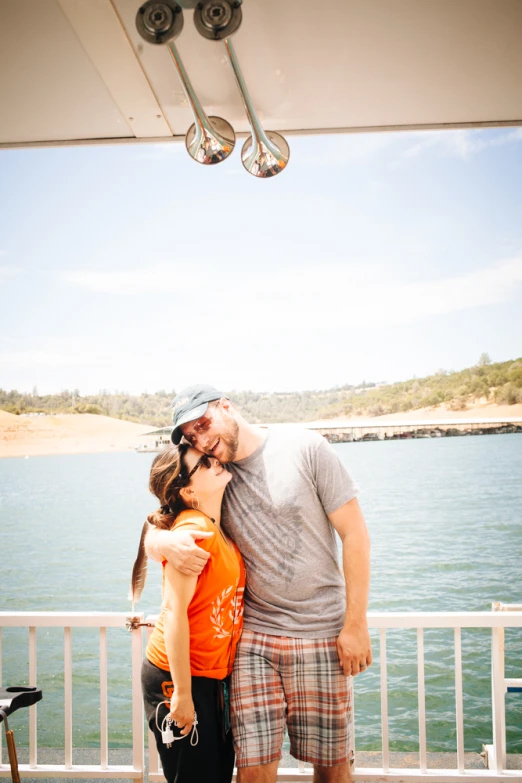 two people that are kissing in front of water