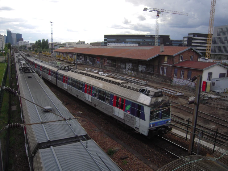 a train in front of a warehouse under construction