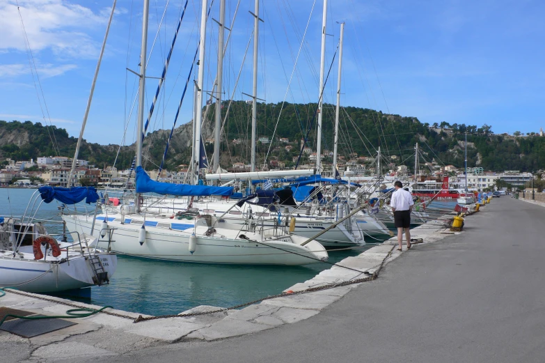 sailboats sit docked near the shore line of a bay