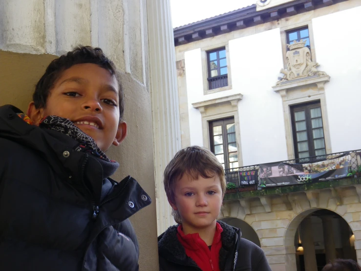 a  and older boy standing outside an historic building