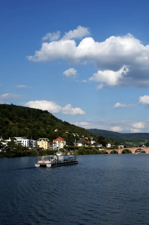 a lake with boats, a bridge and buildings