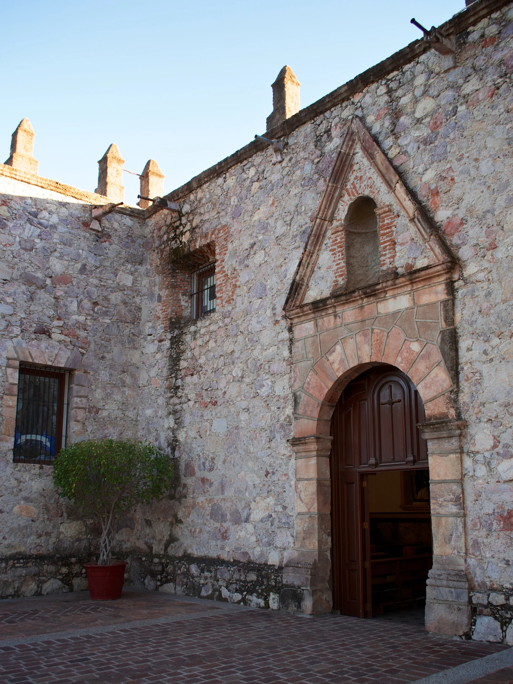 a building with a doorway and brick wall