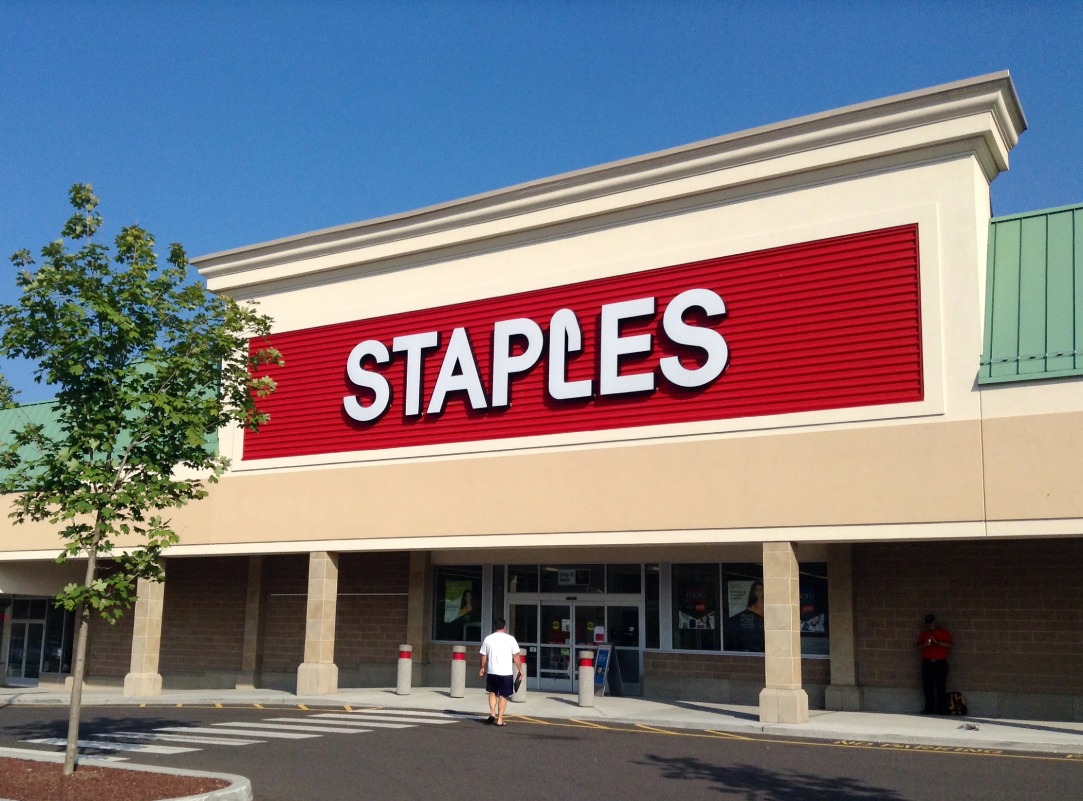 an exterior view of a shop that includes a large sign and trees