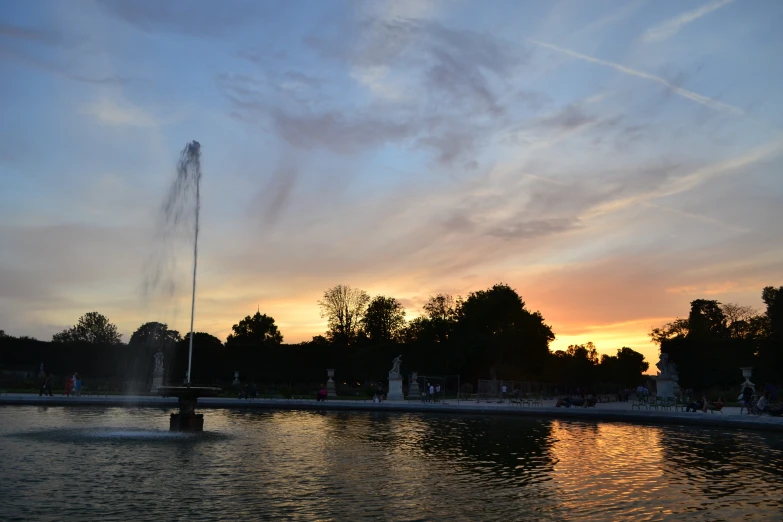 a water fountain sitting near a tall tree