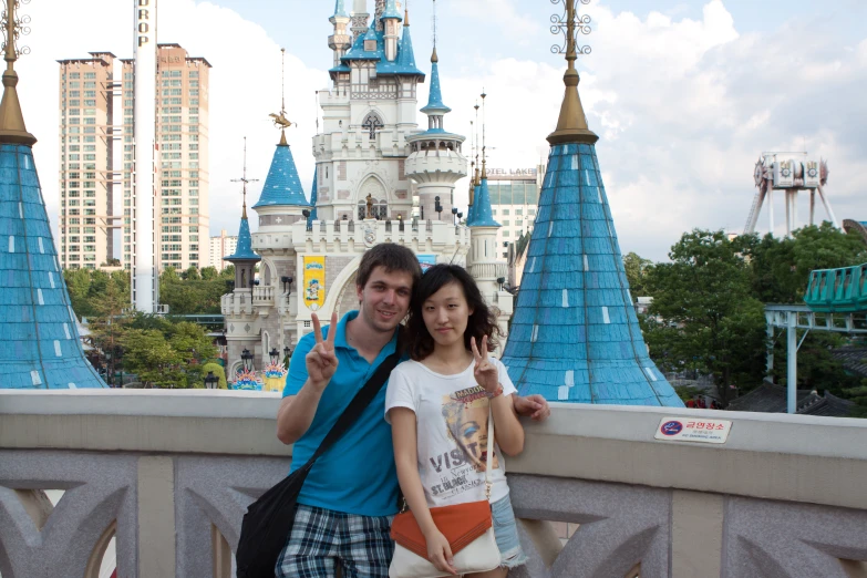 two people pose on a bridge over a pond