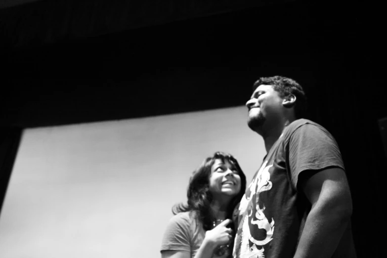 man and woman standing on stage with one holding his eyes open